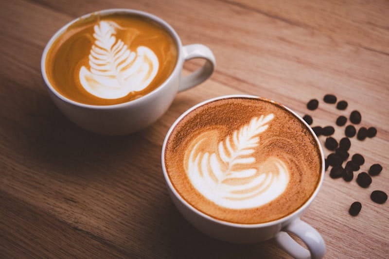 Two cups of coffee on a wooden table