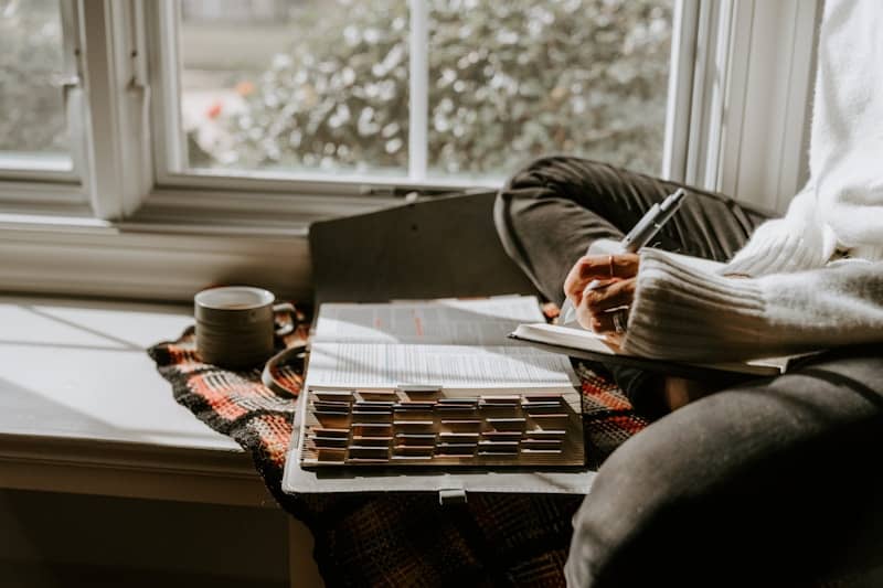 A person sitting in a chair writing on a piece of paper