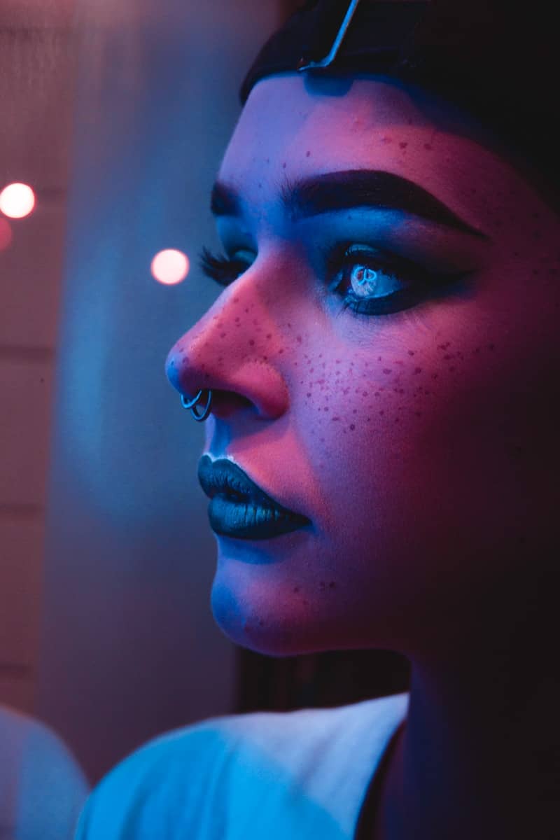 photo of ai generated woman with black lipsticks and nose piercings captured inside dim light room