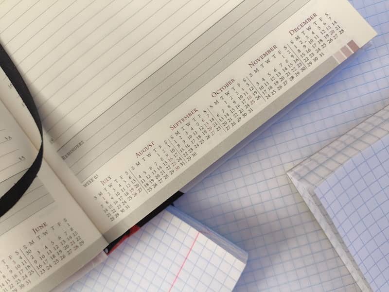 Open planner showing calendar months from June to December with grid paper notebooks