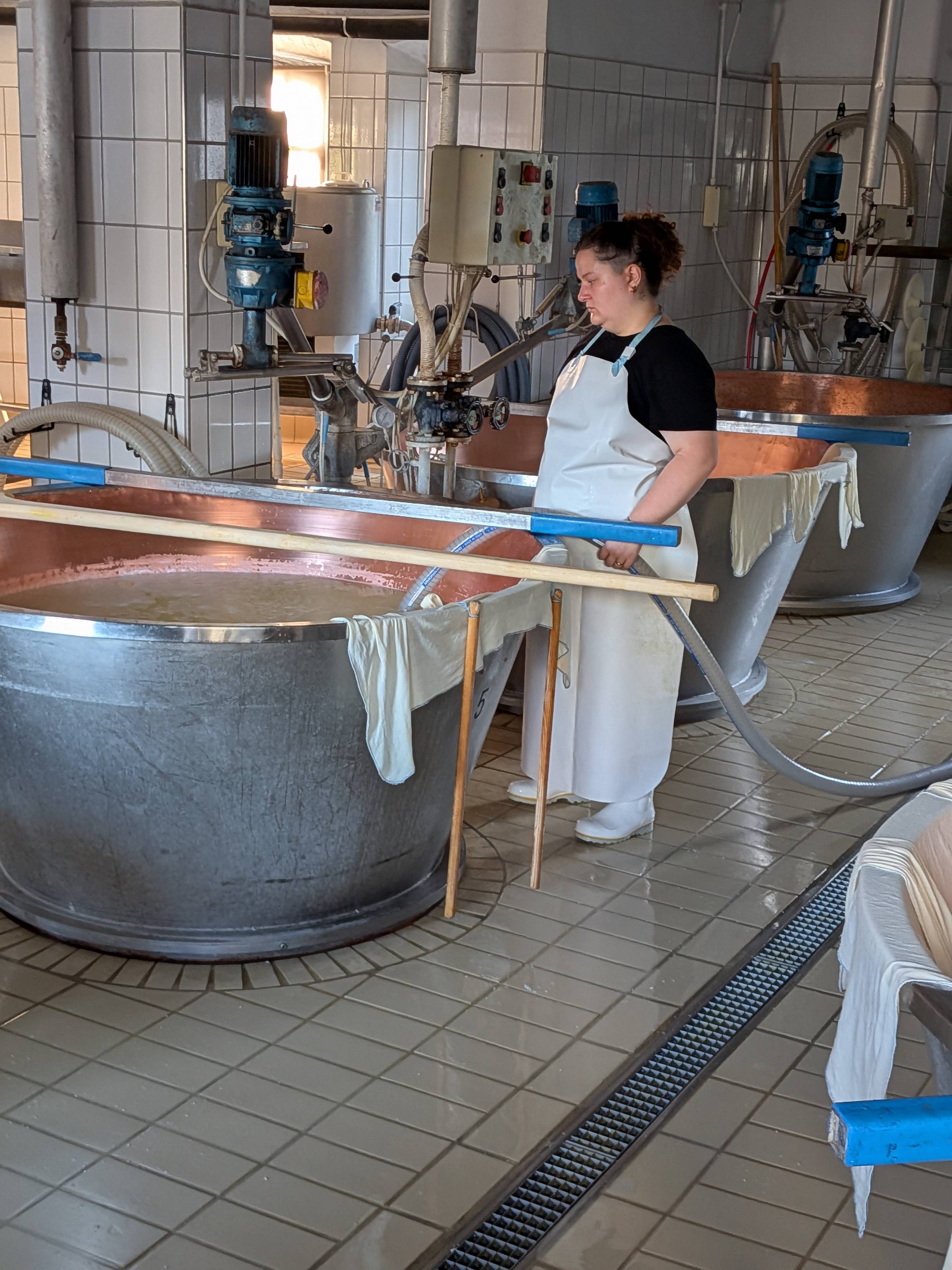 girl holding hose in a vat of milk.