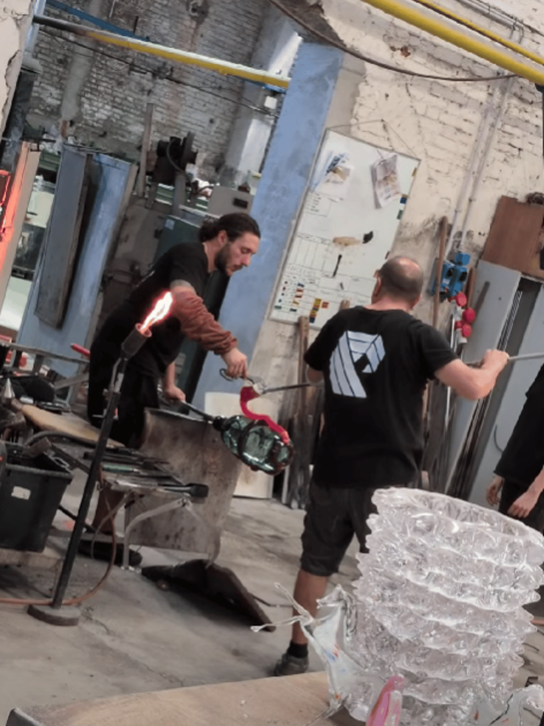 two men making a glass vase