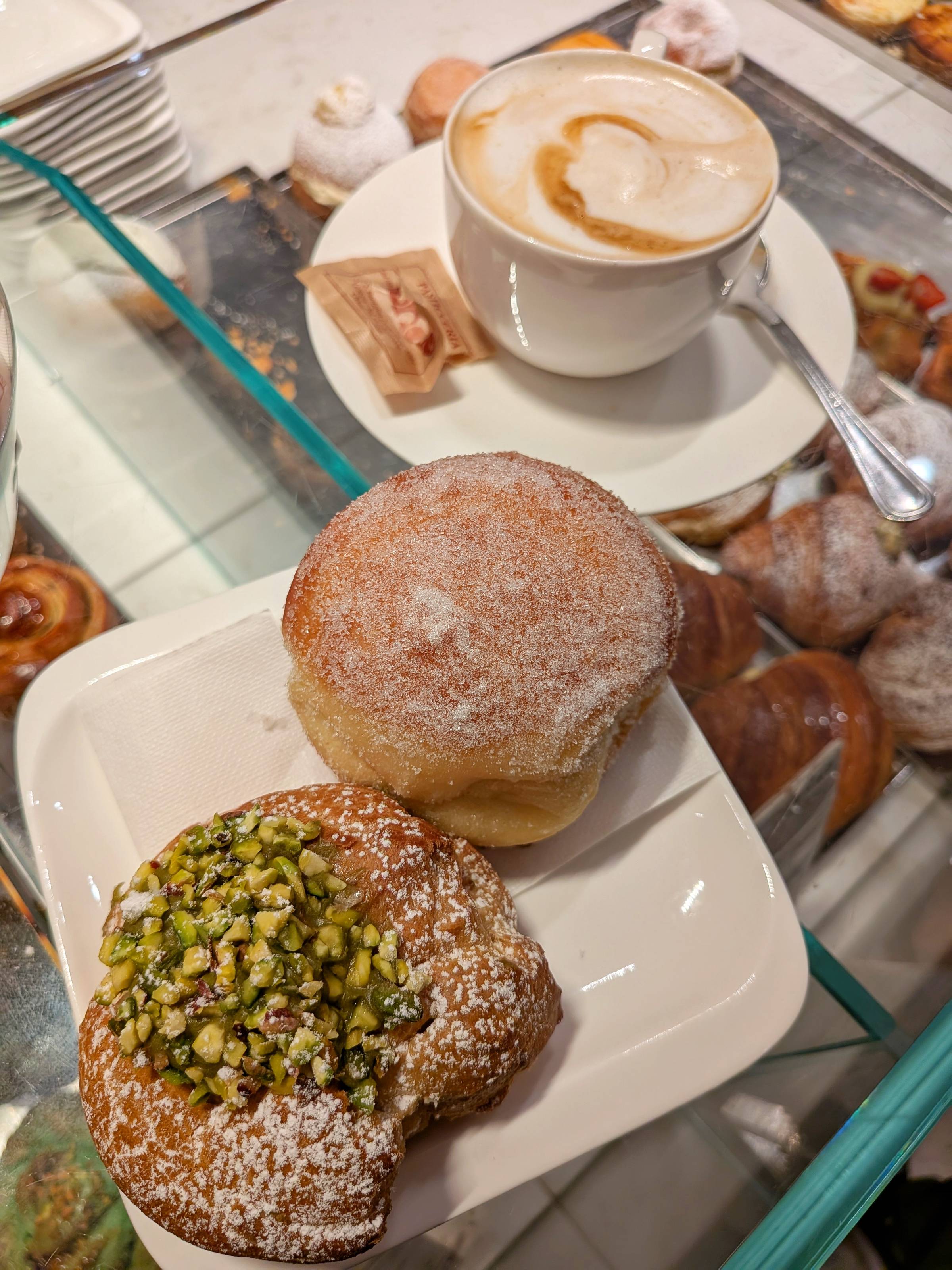 two pastries next to a coffee.