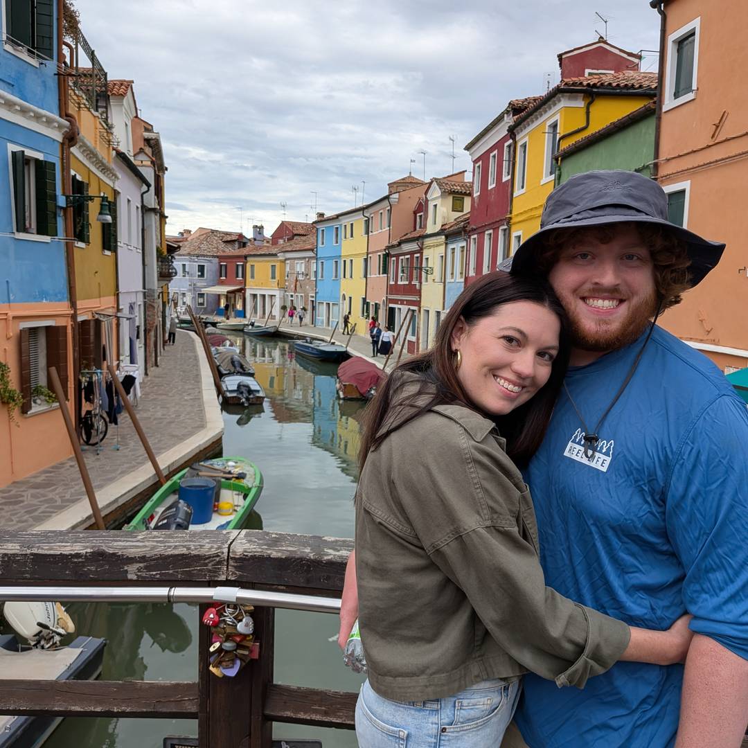 two people in front of colorful houses in Burano.