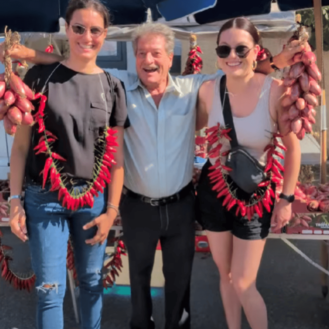 two girls next to a man holding onions