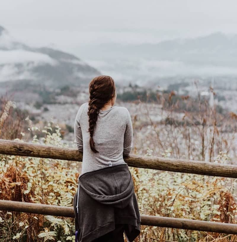 standing woman in grey long-sleeved shirt