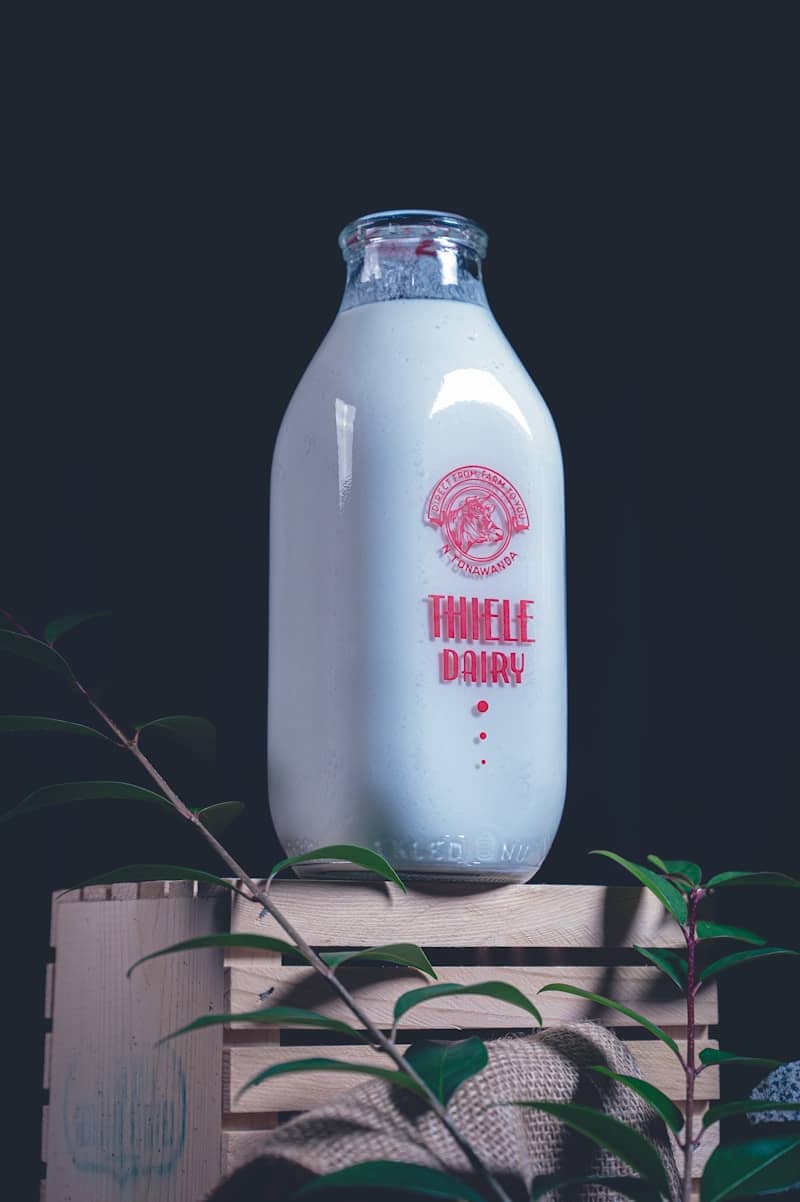 A glass bottle of milk on a wooden crate.