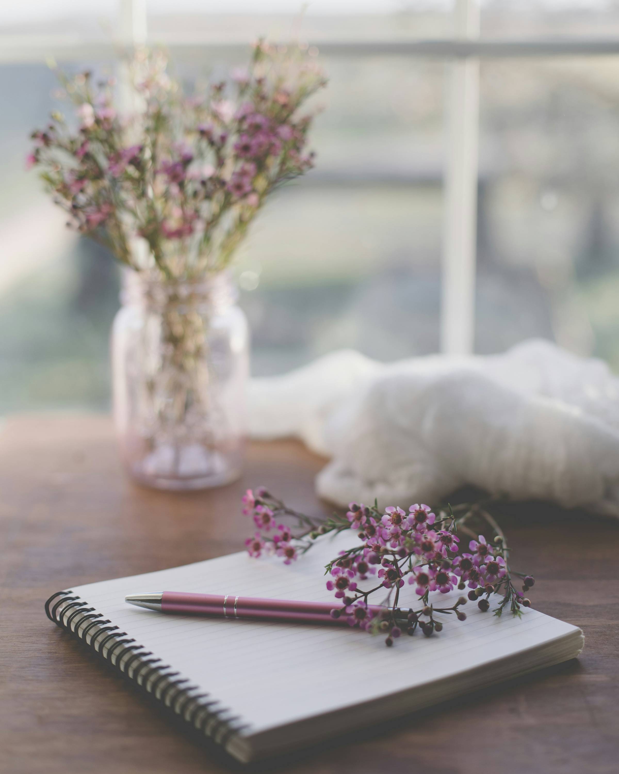A notebook with flowers and some craft supplies.