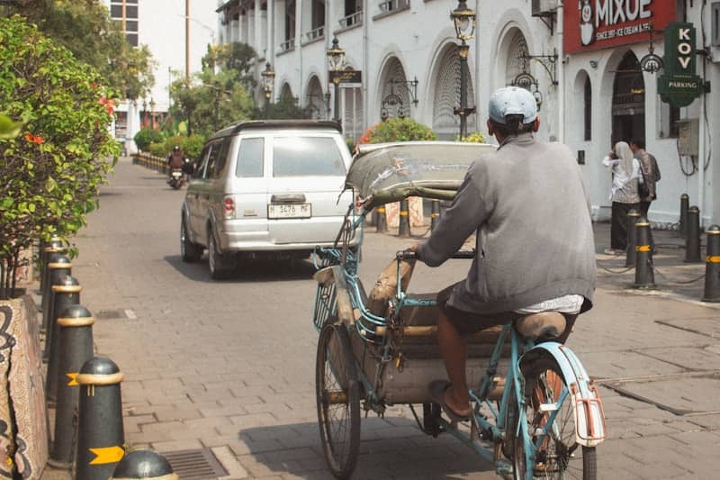 Man riding a pedicab down a street