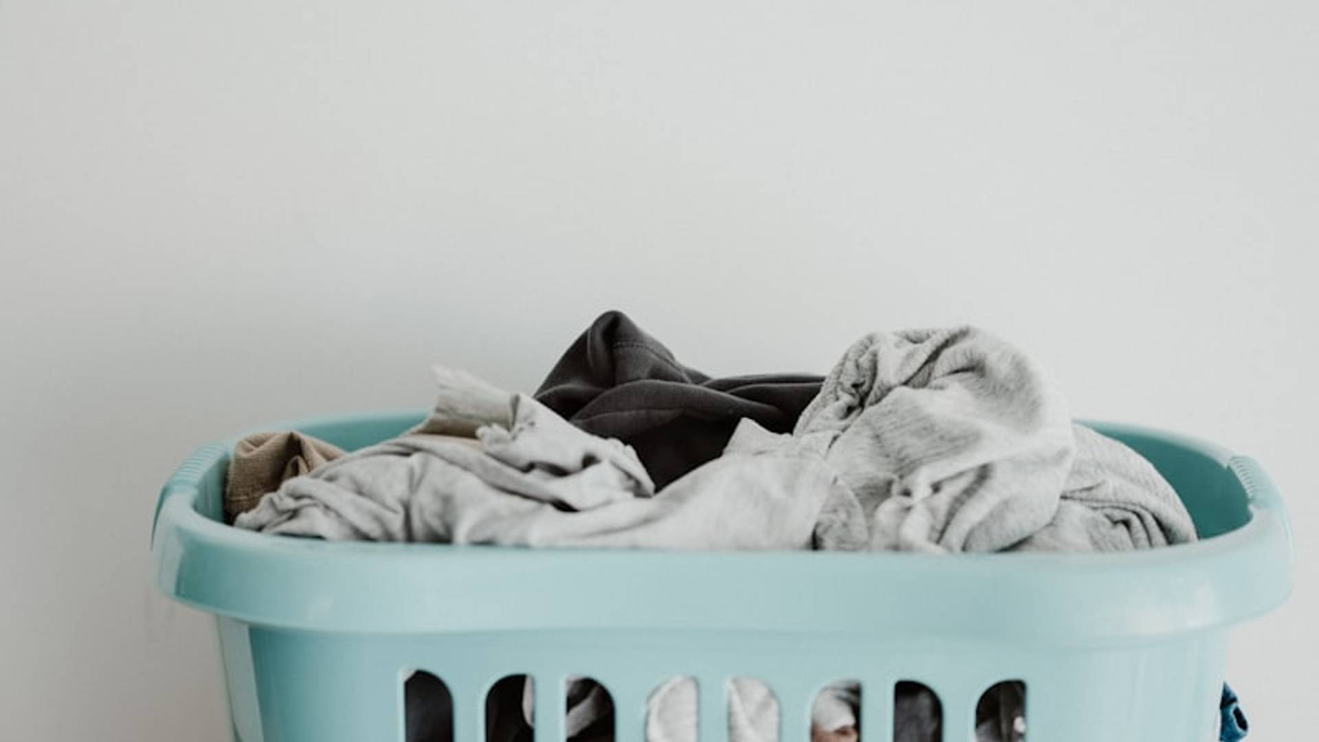 white textile on blue plastic laundry basket