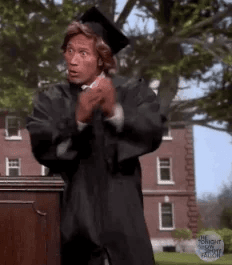 Dwayne "The Rock" Johnson wears a graduation cap and robe and cheers comically on a fake graduation stage