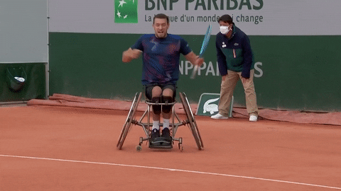 A wheelchair tennis player shouting in celebration