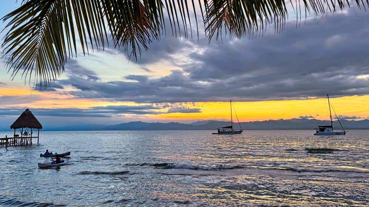 Sunset beach with sailboats at anchor