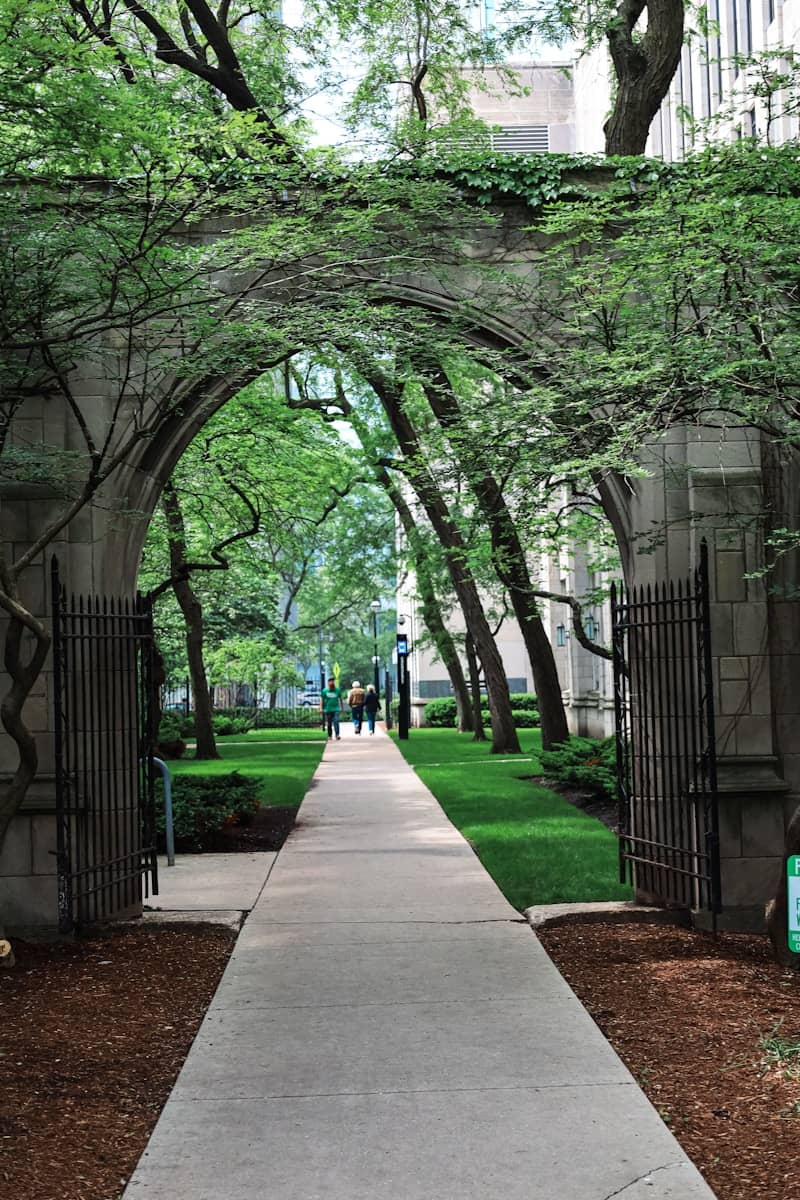 A stone archway leads to a beautiful pathway.