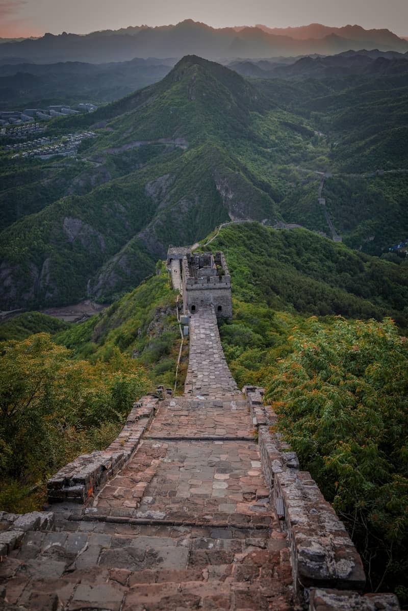 The great wall of china winding through lush green mountains.