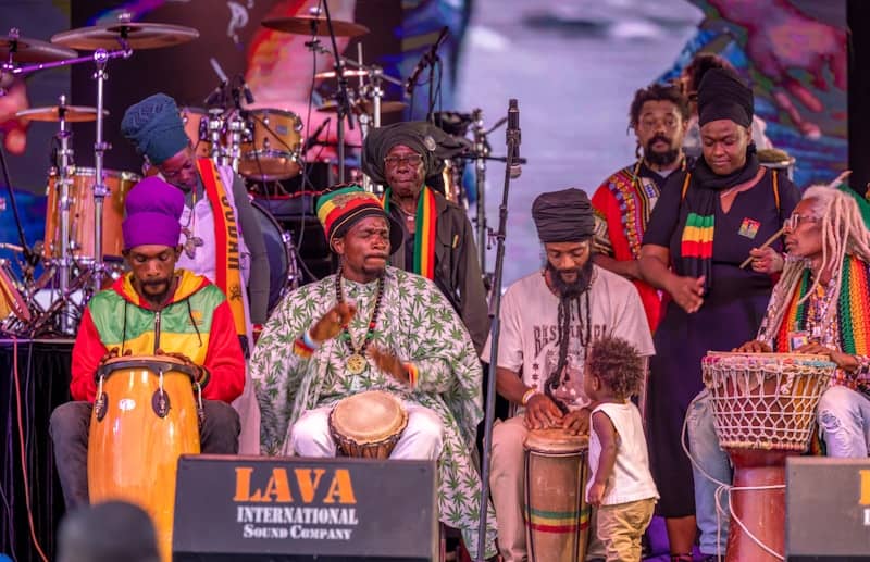 Reggae musicians perform onstage at a concert.