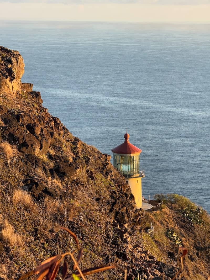 A lighthouse stands on a cliff overlooking the ocean.