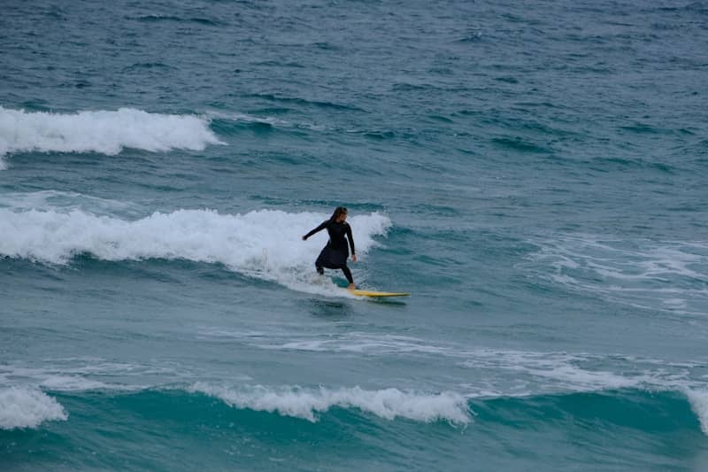 A surfer rides a wave on a surfboard.