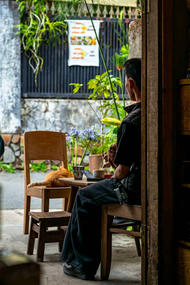 Man and cat at outdoor cafe table