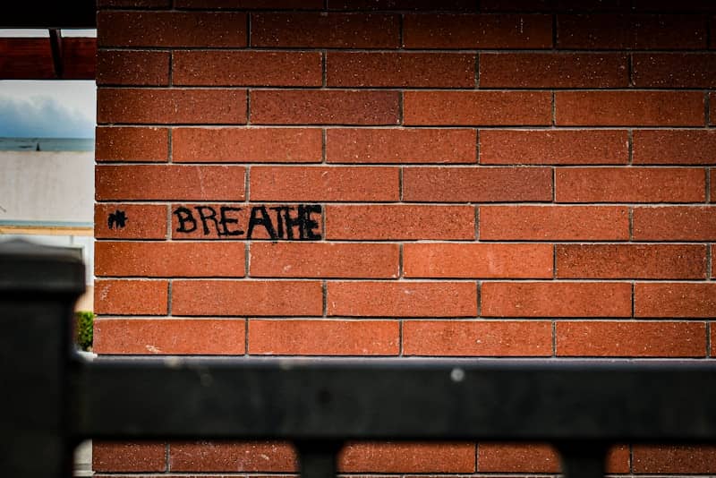 The word "breathe" is written on the brick wall.