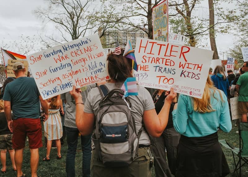 Protesters hold signs at a demonstration about transgender rights.