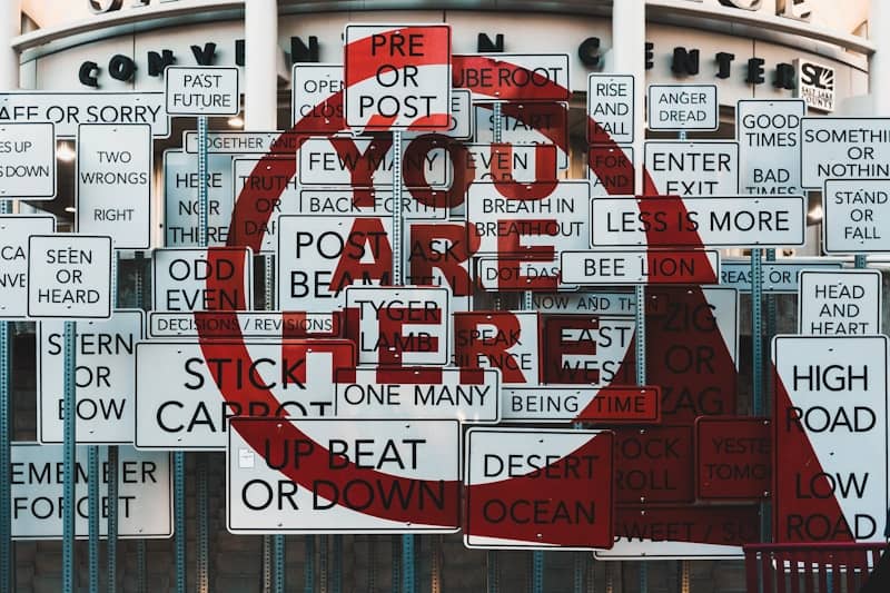 You are here sign with many other signs