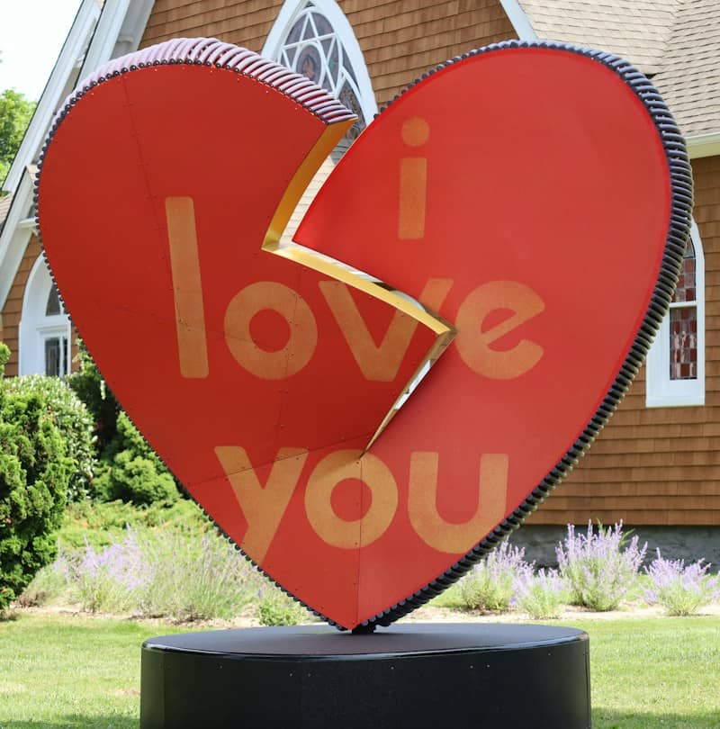 A large red heart sculpture with the words i love you in gold