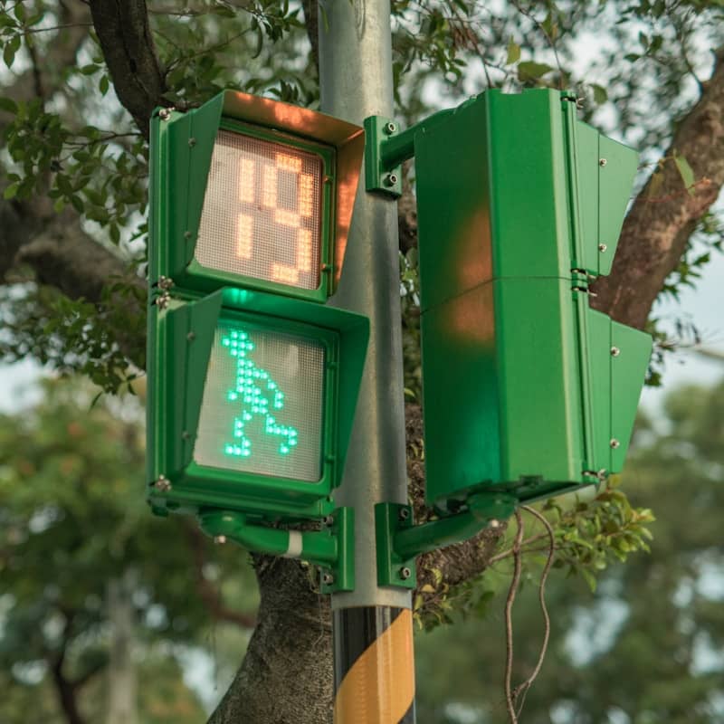 A pedestrian crossing signal shows a green walking person.