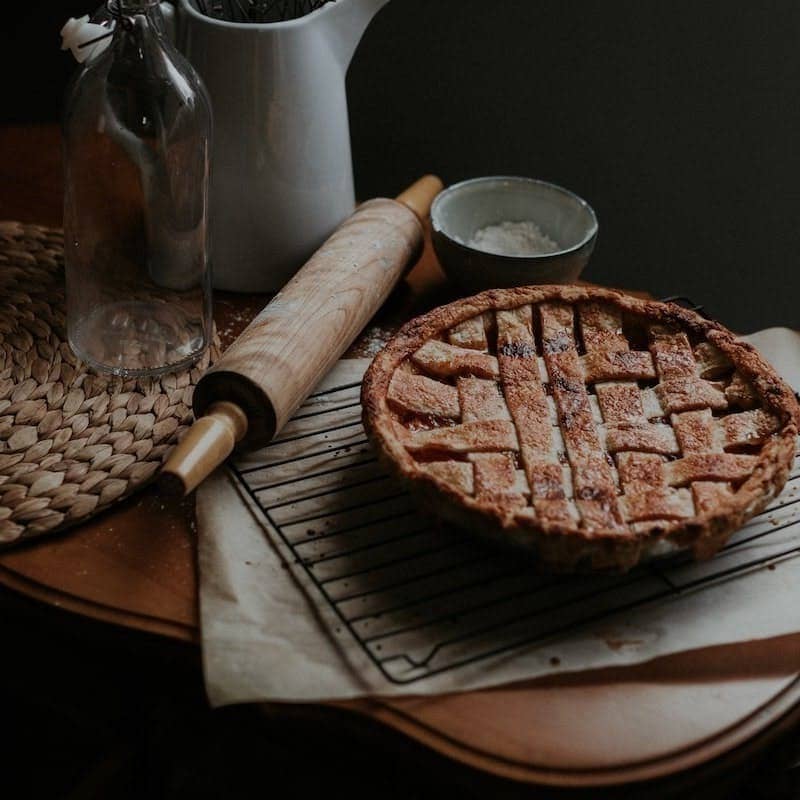 brown bread on brown wooden chopping board beside white pitcher