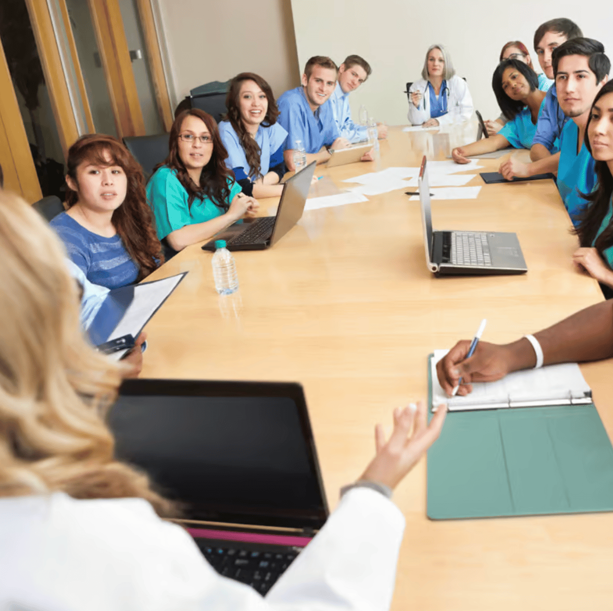 A group of medical professionals discussing latest reports around a conference table.