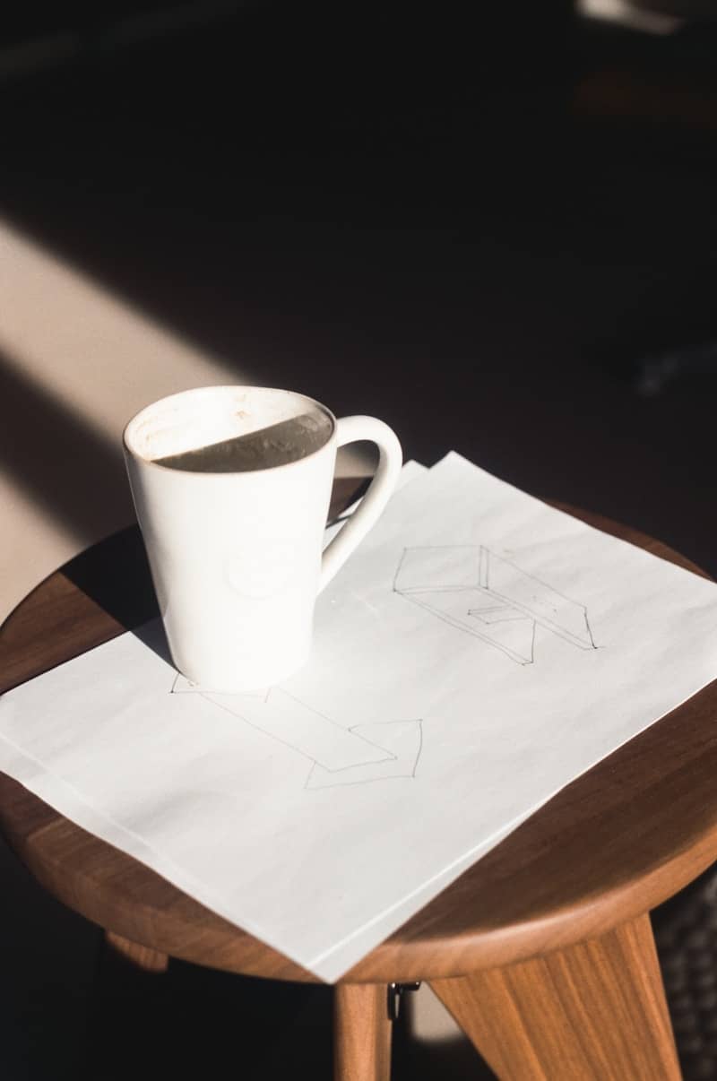 A mug of coffee sits on a drawing.