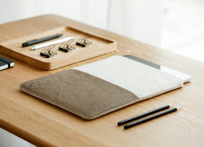 A tablet and pencils on a wooden table.