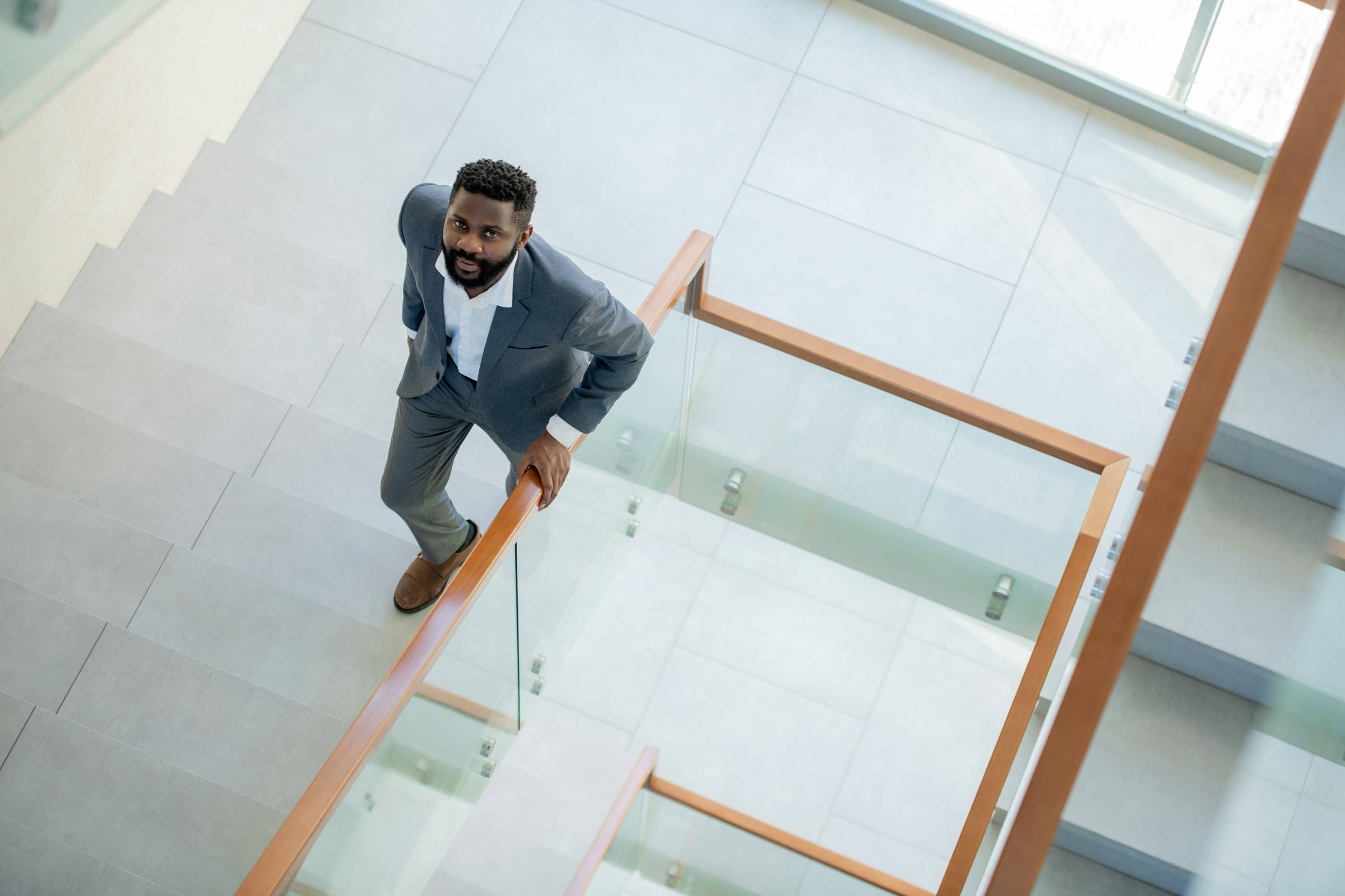A business leader climbing a staircase, symbolizing the leadership shifts required to break through the $10M ceiling and scale fundraising to the next level.