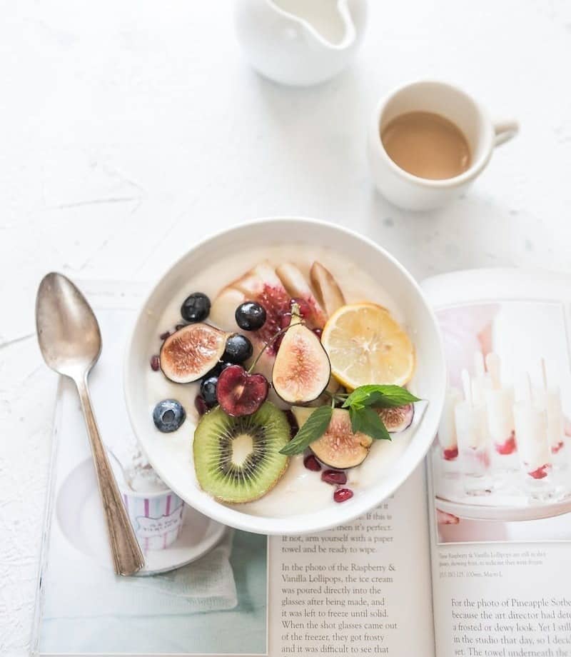 white ceramic plate beside gray steel spoon