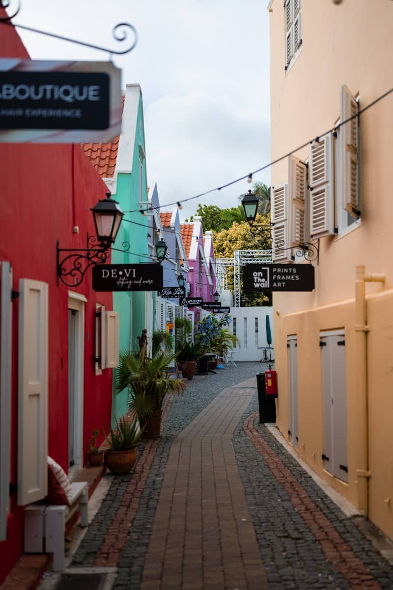 A narrow cobblestone street lined with colorful buildings