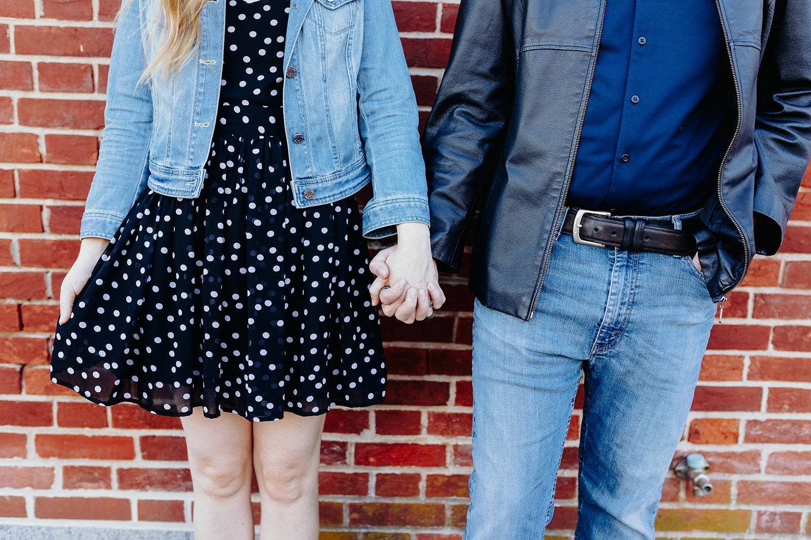 man and woman holding hands together in walkway during daytime