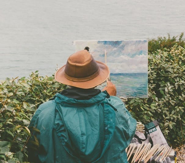 Artist painting the sea while looking at the sea