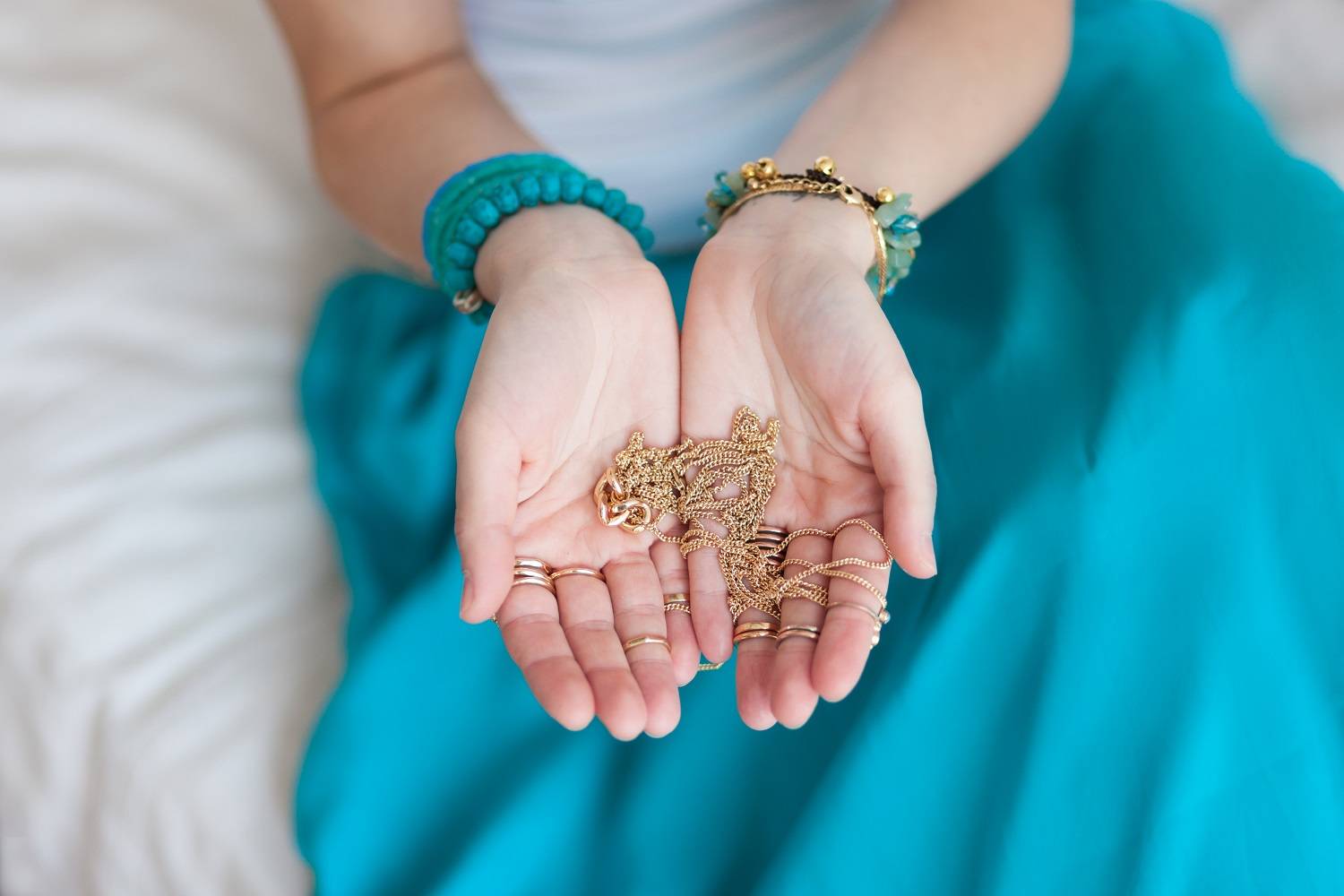 woman holding gold chain necklace