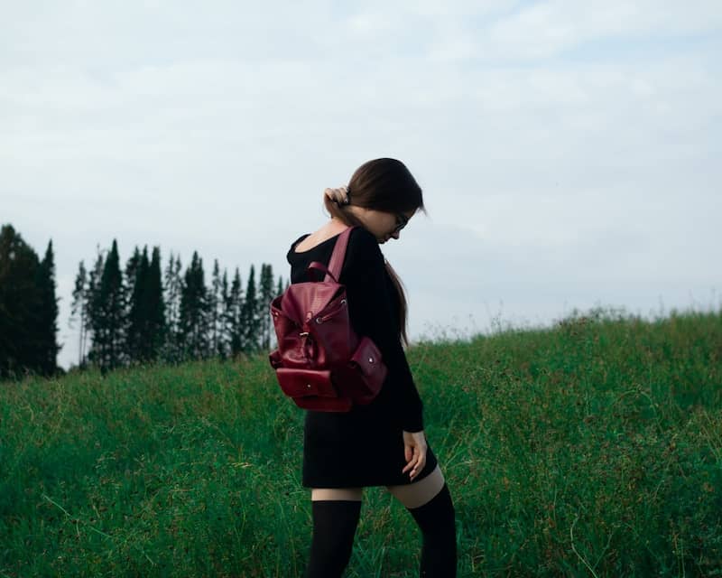 A person walks through a grassy field.