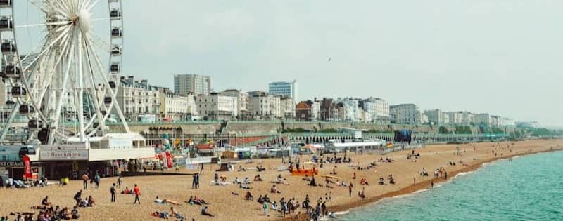 A beach with a ferris wheel on a sunny day.