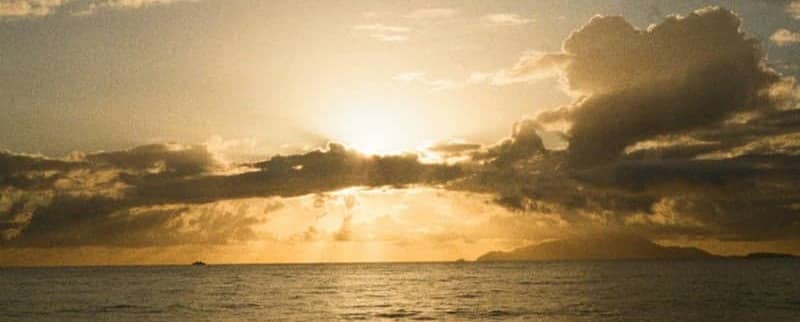 Golden sunset over the calm ocean with clouds