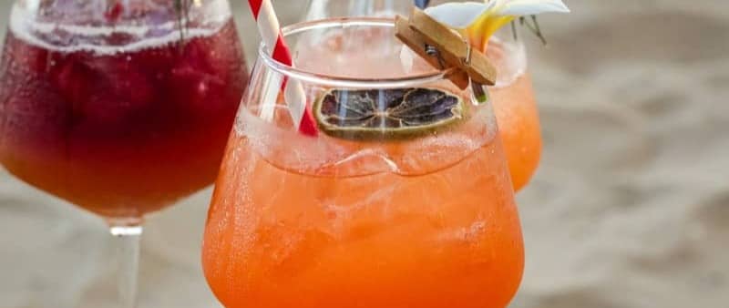 Three colorful cocktails are shown in elegant glasses.