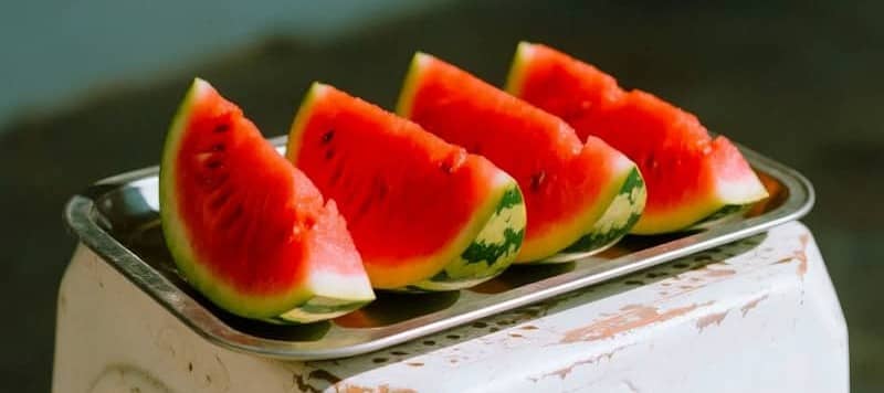 Watermelon slices sit on a tray.