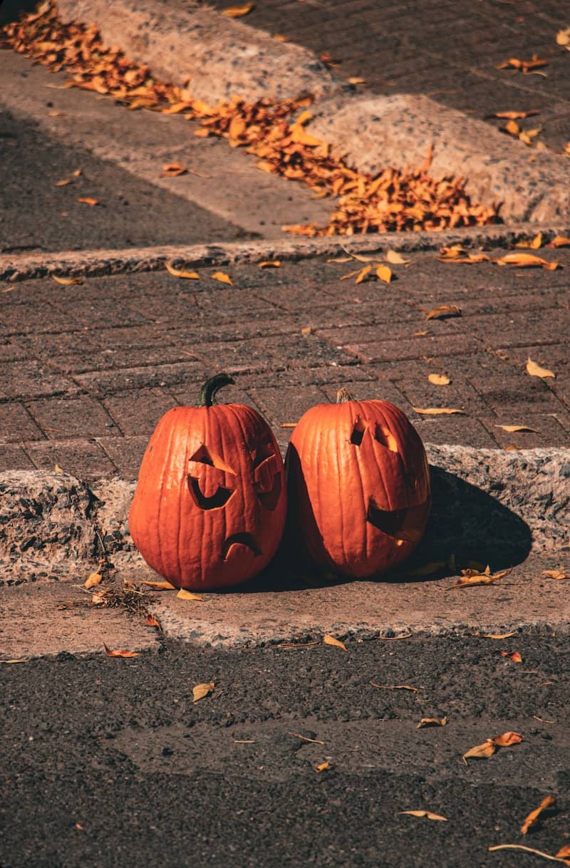 Two carved pumpkins with different expressions sit outside.