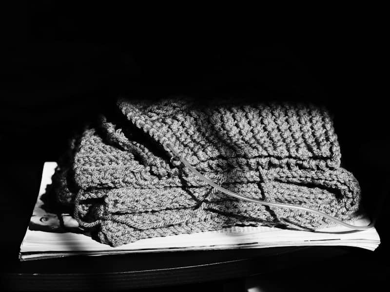 Folded knitted fabric on a stack of papers.