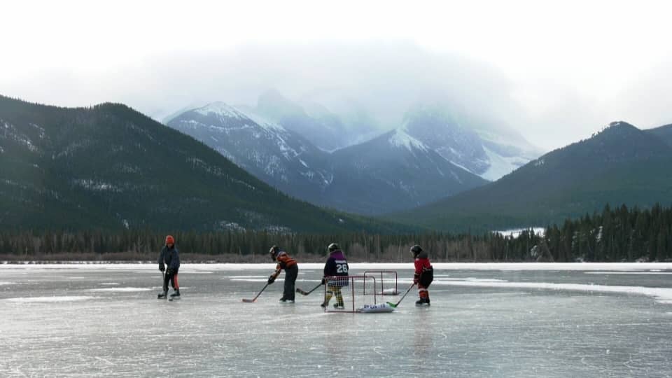 Kids playing hockey on a frozen lake
