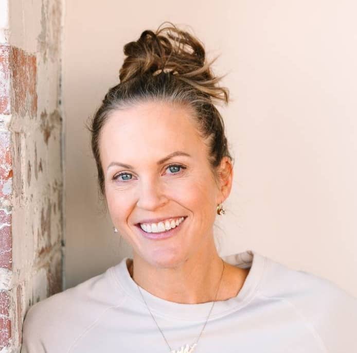 Lydia standing against a brick wall.