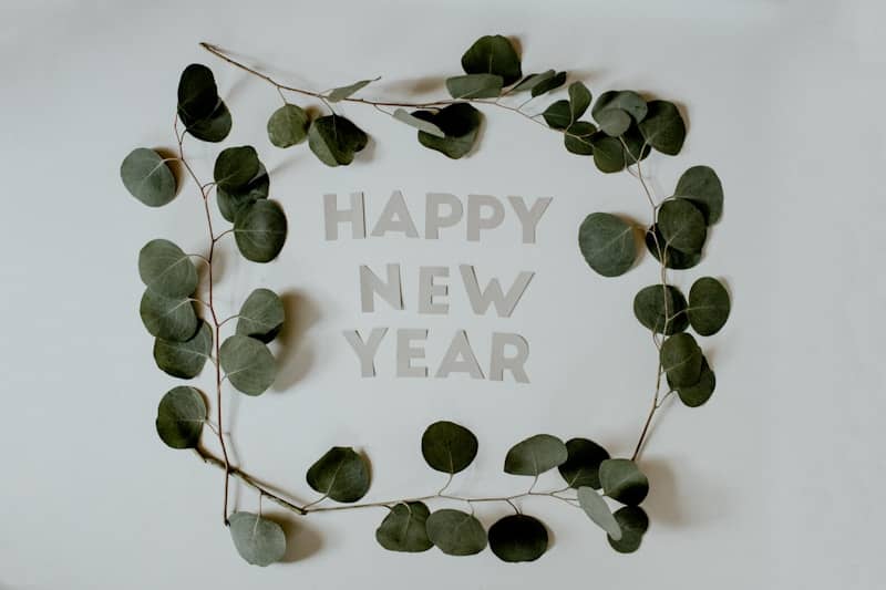 green leaves with happy new year text
