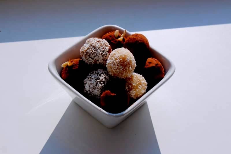 Delicious truffles are presented in a white bowl.
