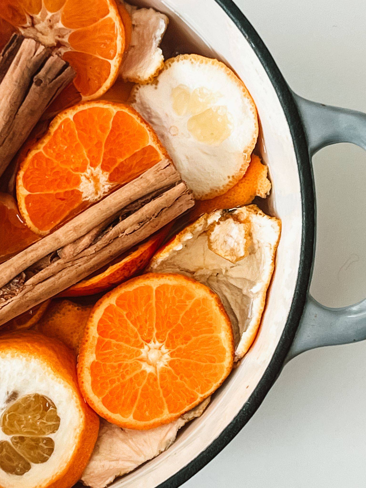 enamel pot filled with cinnamon sticks and sliced oranges